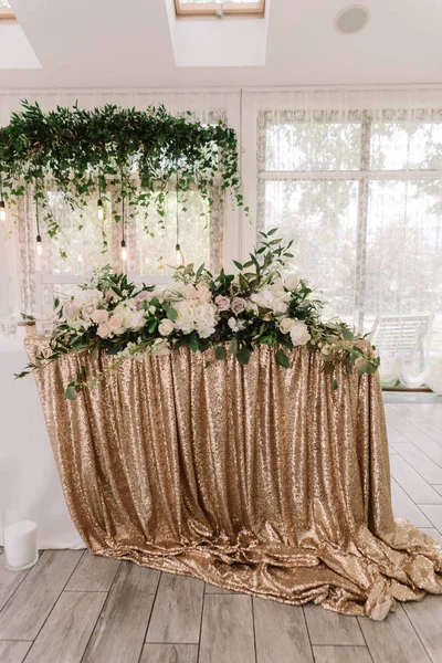 The golden cloth on a wedding table and a lot of beautiful wedding floristics — Stock Photo, Image