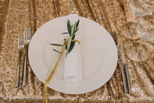 Біла серветка прикрашена золотою ниткою і гілкою евкаліпта — стокове фото