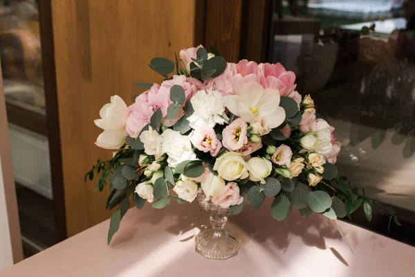 Composizione da fiori - decorazione di un tavolo per ospiti. Candele bianche in grandi vasi di vetro — Foto Stock