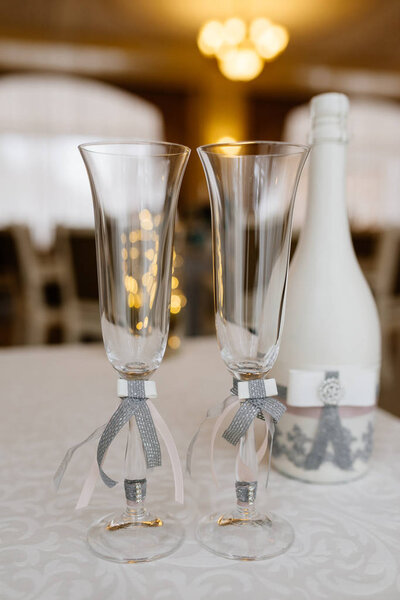 Glasses of the groom and bride on a wedding table. Stylish wedding details