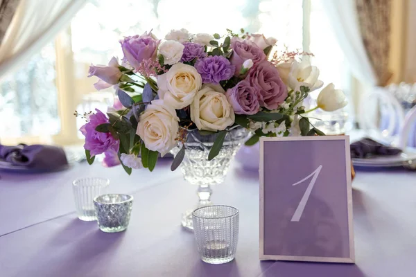 Decoração clássica de uma mesa de casamento pela composição baixa de flores e um cartão com o número de uma mesa — Fotografia de Stock