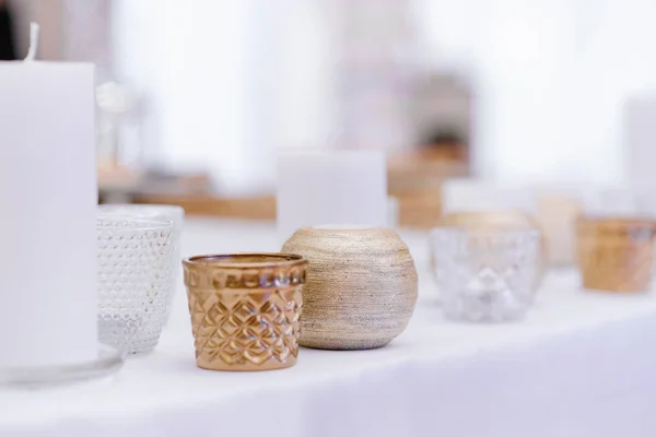Uma variedade de castiçais e velas na mesa branca. Decoração minimalista de casamento moderno — Fotografia de Stock