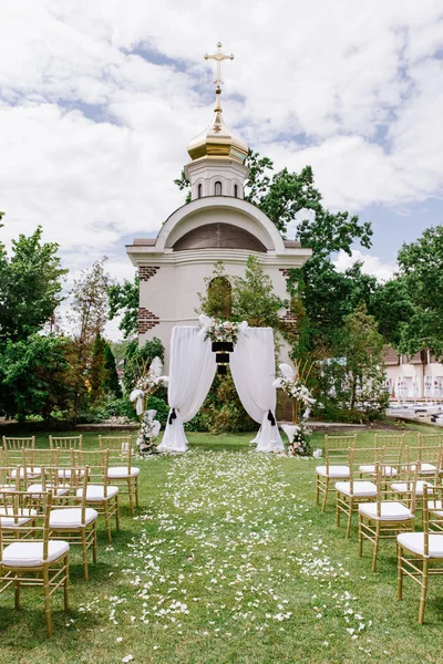 Cerimônia de casamento ao ar livre contra o pano de fundo da Igreja Ortodoxa no verão no gramado — Fotografia de Stock