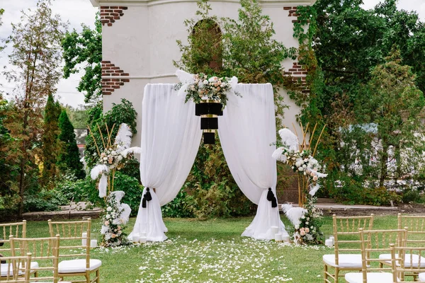 O arco quadrado é decorado com pano branco aéreo e lustre preto elegante — Fotografia de Stock
