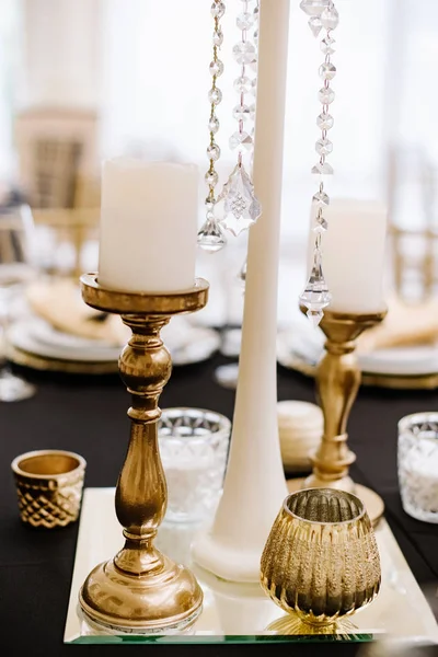 Ψηλά χρυσά κηροπήγια με λευκά κεριά διακοσμήσετε το τραπέζι στην εκδήλωση — Φωτογραφία Αρχείου