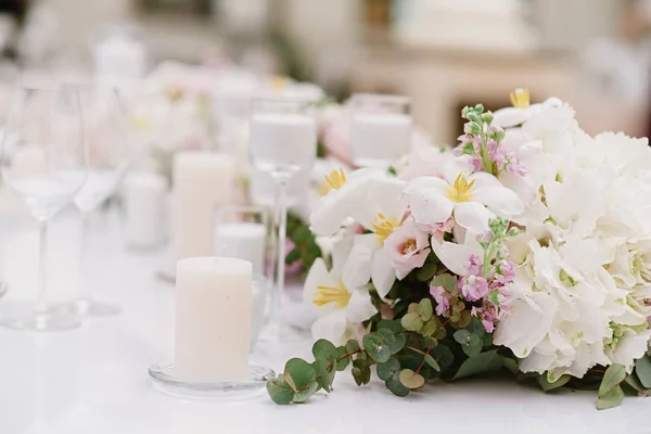 Luxuriöse Dekoration des Hochzeitstisches mit weißen Kerzen und Blumen in hellen Farbtönen — Stockfoto