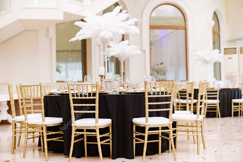 Black tablecloths on big, round tables for a wedding lunch.