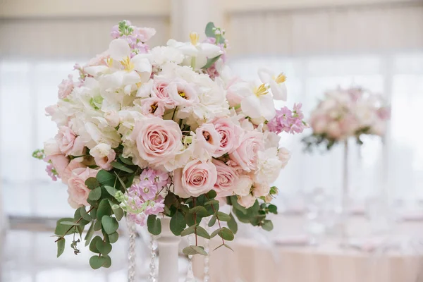 Flores de boda grandes, rosas blancas y crema, hojas de eucalipto decoran la sala de banquetes del restaurante — Foto de Stock