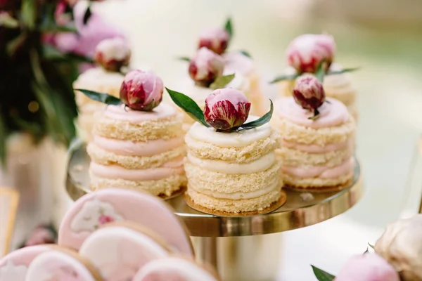 Cakes with natural cream, berries and air biscuit stand on a golden stand