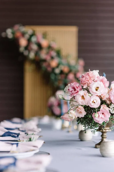 Luxurious wedding table for guests at the wedding. Pink flowers in beautiful vases