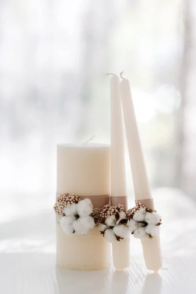 Elegant decoration of white wedding candles for the ceremony with white cotton and lace made of sackcover — Stock Photo, Image