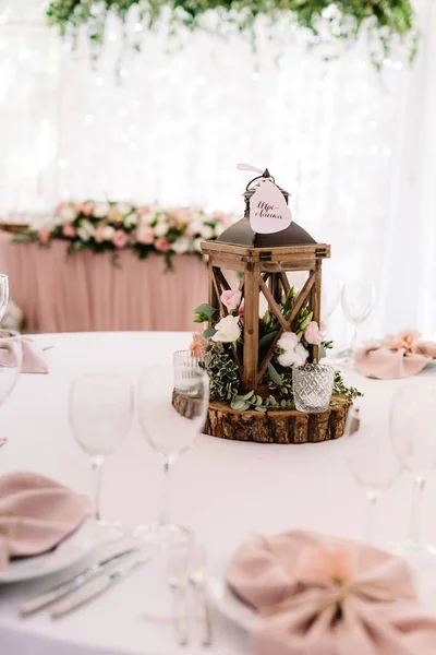 A bela decoração original de madeira, flores e velas fica no meio da mesa de jantar — Fotografia de Stock