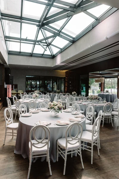 Tables rondes de vacances dans le grand hall spacieux du restaurant avec des plafonds en verre . — Photo