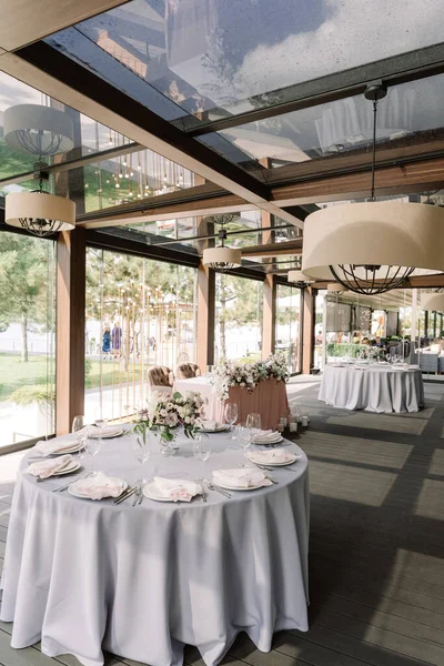 高価なきれいな料理と結婚式で丸いテーブルのお祭りのサービス、ガラス花瓶の花の花束. — ストック写真