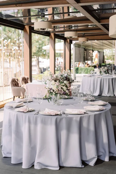 Lujoso diseño de boda para una boda moderna. Mantel gris en el suelo en la mesa redonda —  Fotos de Stock