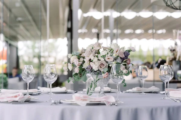 休日のラウンドテーブルのガラス花瓶の新鮮な花の豪華な花束 — ストック写真