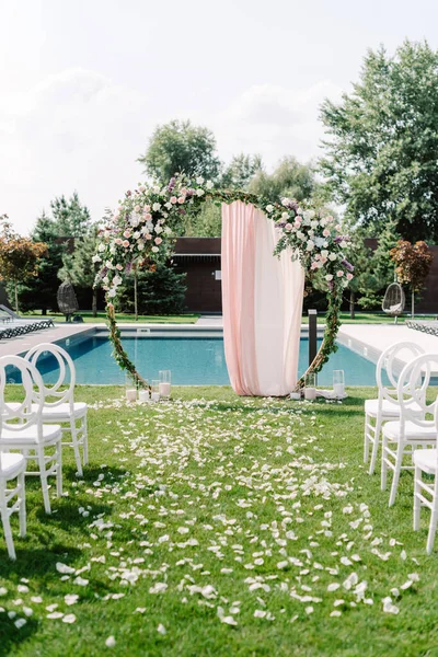 Decoração de casamento para o casamento do jardim no verão. Arco redondo decorado com verdes e pano rosa — Fotografia de Stock