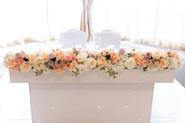โต๊ะของคู่แต่งงานใหม่เป็นรูปสี่เหลี่ยมและสีขาวตกแต่งด้วยสีสดของเฉดสีพาสเทล . — ภาพถ่ายสต็อก