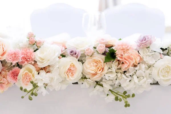 Um lindo buquê em uma mesa de casamento alongada feita de rosas de diferentes tons — Fotografia de Stock