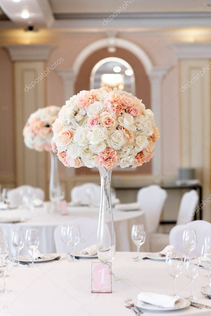 A large composition from an assortment of beautiful flowers elegantly adorns the dining table