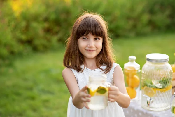小女孩站在公园里喝天然柠檬水. — 图库照片
