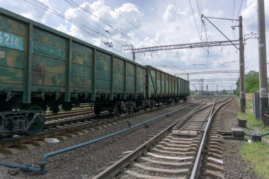 Tren şehir, mavi gökyüzü ve bulutlar ile güneşli bir gün üzerinden bir demiryolu geçer. Kiev, Ukrayna.