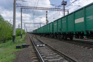 Tren şehir, mavi gökyüzü ve bulutlar ile güneşli bir gün üzerinden bir demiryolu geçer. Kiev, Ukrayna.