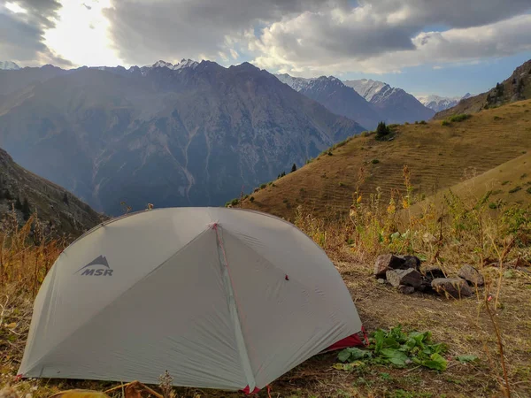 Almat şehri yakınlarındaki Kazakistan'da Tien Shan sisteminin Trans-Ili Alatau sıradağları. Yaz ortasında bulutların altında karla kaplı kayalık zirveler