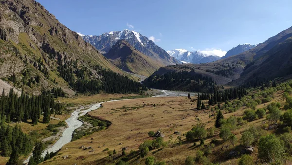 Almat şehri yakınlarındaki Kazakistan'da Tien Shan sisteminin Trans-Ili Alatau sıradağları. Yaz ortasında bulutların altında karla kaplı kayalık zirveler