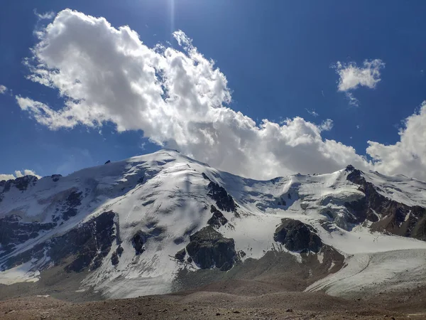 哈萨克斯坦的天山山脉的跨伊犁阿拉托山脉靠近阿拉木图市 夏中云层下覆盖着雪和冰川的落基山峰 — 图库照片