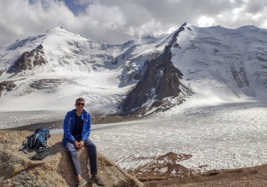 Almat şehri yakınlarındaki Kazakistan'da Tien Shan sisteminin Trans-Ili Alatau sıradağları. Yaz ortasında bulutların altında karla kaplı kayalık zirveler