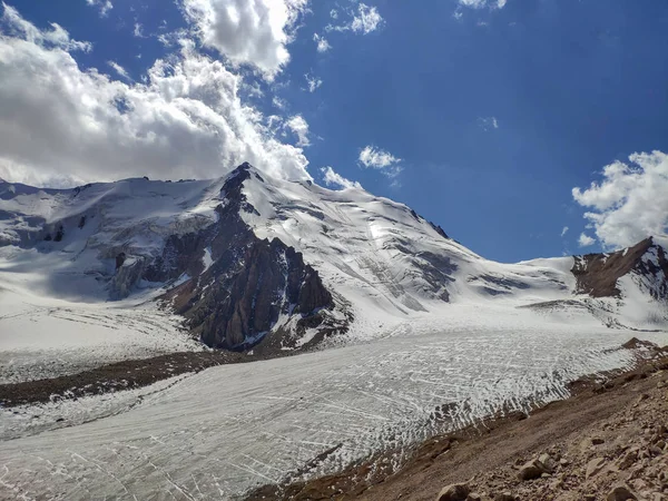 アルマトイ市に近いカザフスタンのティエンシャン系のトランスイリアラタウ山脈 雲の下で夏の真ん中に雪と氷河で覆われた岩のピーク — ストック写真