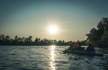 Kiev / Ukrayna - 14 Eylül 2019: Kayaklarda yüzmek. Arka planlarda güzel doğa ile birlikte gölde kano gençlerin arka görünümü.