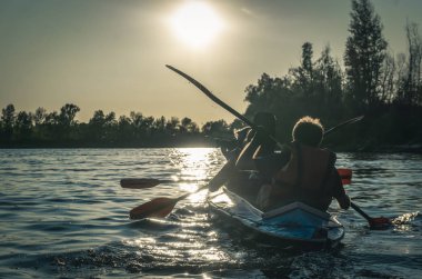 Kiev / Ukrayna - 14 Eylül 2019: Kayaklarda yüzmek. Arka planlarda güzel doğa ile birlikte gölde kano gençlerin arka görünümü.