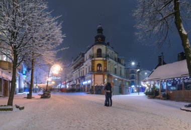 Zakopane karda ana caddesi çift öpüşme akşam, Polonya. Europe.