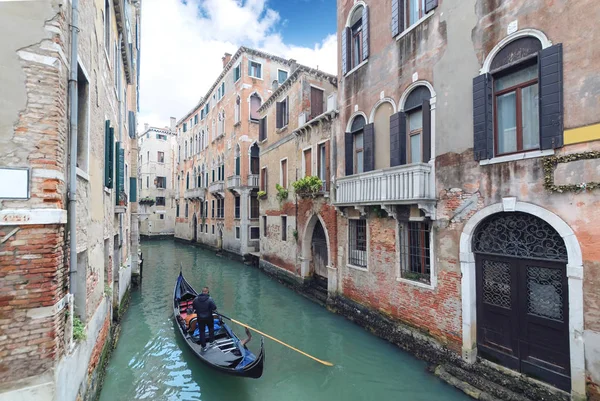 Gondolier haciendo una góndola a través del canal verde en Venecia . — Foto de Stock