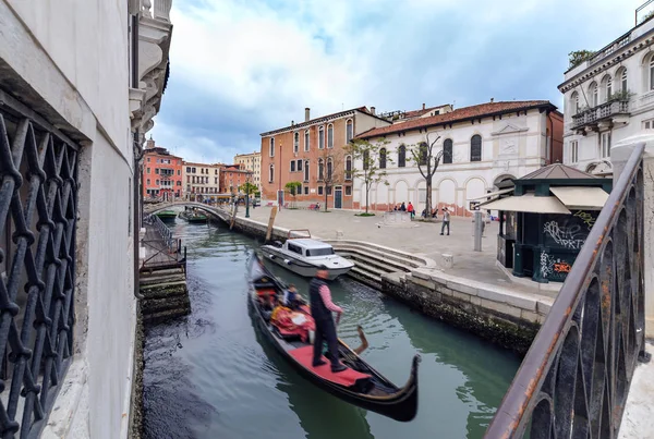 Gondolier punting gondola through the canal in Venice. — Stock Photo, Image