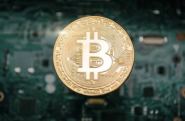 Bitcoin coin, on background of computer motherboard. — Stock Photo, Image