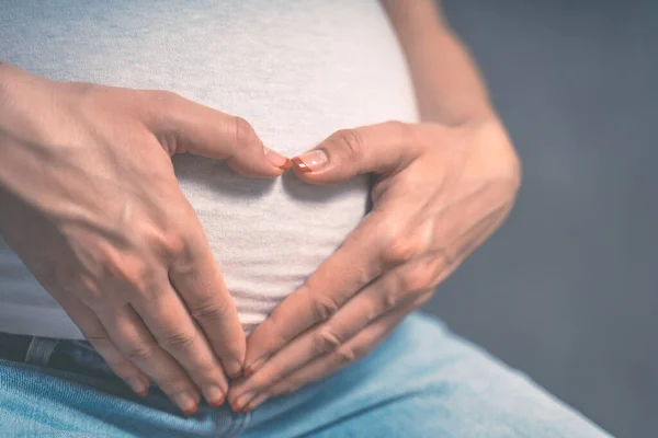 Hamile Bir Kadın Bebeğinin Karnında Elini Kalp Şeklinde Tutuyor Parmakları — Stok fotoğraf