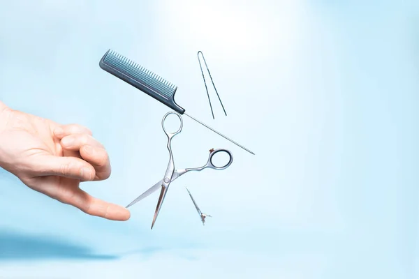 Had holding flying hairdresser tools comb, scissors under trendy color background with copy space and soft light. Stylish Professional Barber Scissors, Hairdresser salon concept, Haircut accessories. — Stock Photo, Image