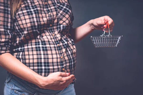 Hamilelik alışverişi, annelik, insanlar ve beklenti konsepti. Alışveriş arabasıyla karnına dokunan hamile bir kadın. Tonu ayarlanmış resim — Stok fotoğraf