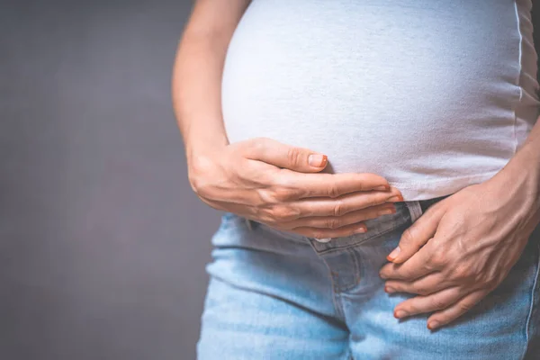 Hamile Bir Kadın Gri Bir Arka Planda Ele Tutuşuyor Hamilelik — Stok fotoğraf
