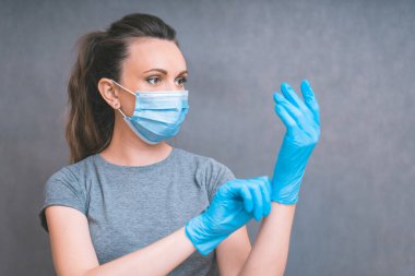Yang kadın mavi eldiven giydi. Sağlık ve Enfeksiyon Konsepti. Tıbbi Yüzlü Kadın ve grip ve virüslere karşı mavi eldivenler, boşluğu kopyala.