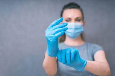 Yang kadın mavi eldiven giydi. Sağlık ve Enfeksiyon Konsepti. Tıbbi Yüzlü Kadın ve grip ve virüslere karşı mavi eldivenler, boşluğu kopyala.