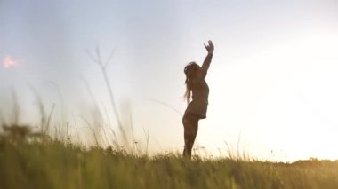 Genç kadının gün batımında Yoga pratik yapması