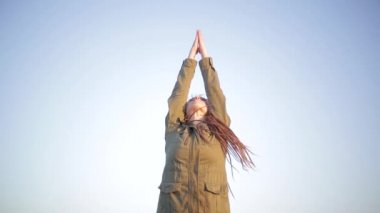 Genç kadının gün batımında Yoga pratik yapması