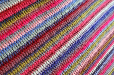 Renkli tığ işi iplik tarafından oluşturulan bir arka plan desen. Pembe, yeşil ve mavi şeritler halinde el yapımı bir battaniye  