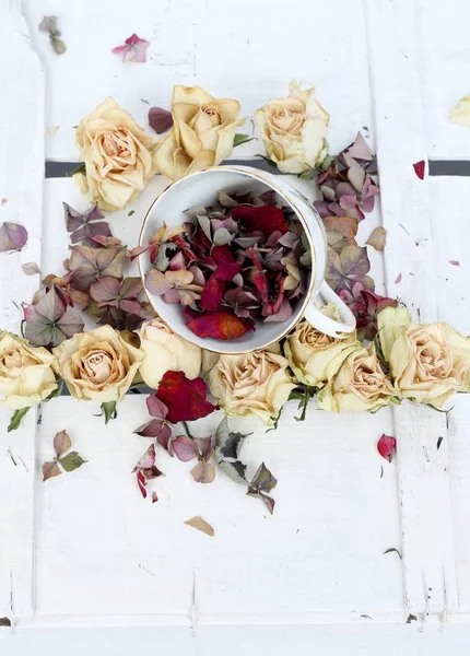 中国茶カップ乾燥したバラとアジサイの花びらの白い木製の背景にビンテージ スタイルみすぼらしいシックな花画像 — ストック写真