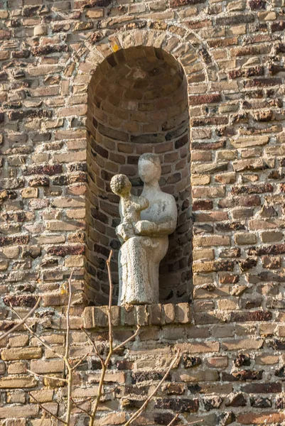Egmond-Binnen, Hollanda-04-10-2016: çocuk İsa'nın kucağına oynama ile Meryem heykeli oturma ile niş. Gatebuilding, St. Lioba-manastır, Egmond-Binnen detay.