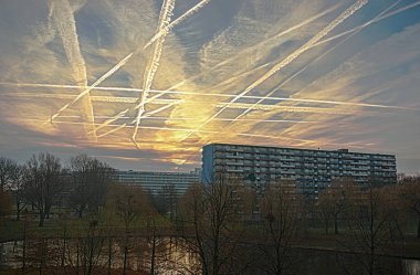 Satranç tahtası gökyüzü, beyaz buharı yollar gelen veya Schiphol Havaalanı yakın olacak Plains ile. Güneş doğarken 'hava yolları-geçiş noktası' Kikkenstein ve Kruitgerg Bijlmermeer apartman binaları yukarıda gösterilen büyüleyici bir desen. Amster